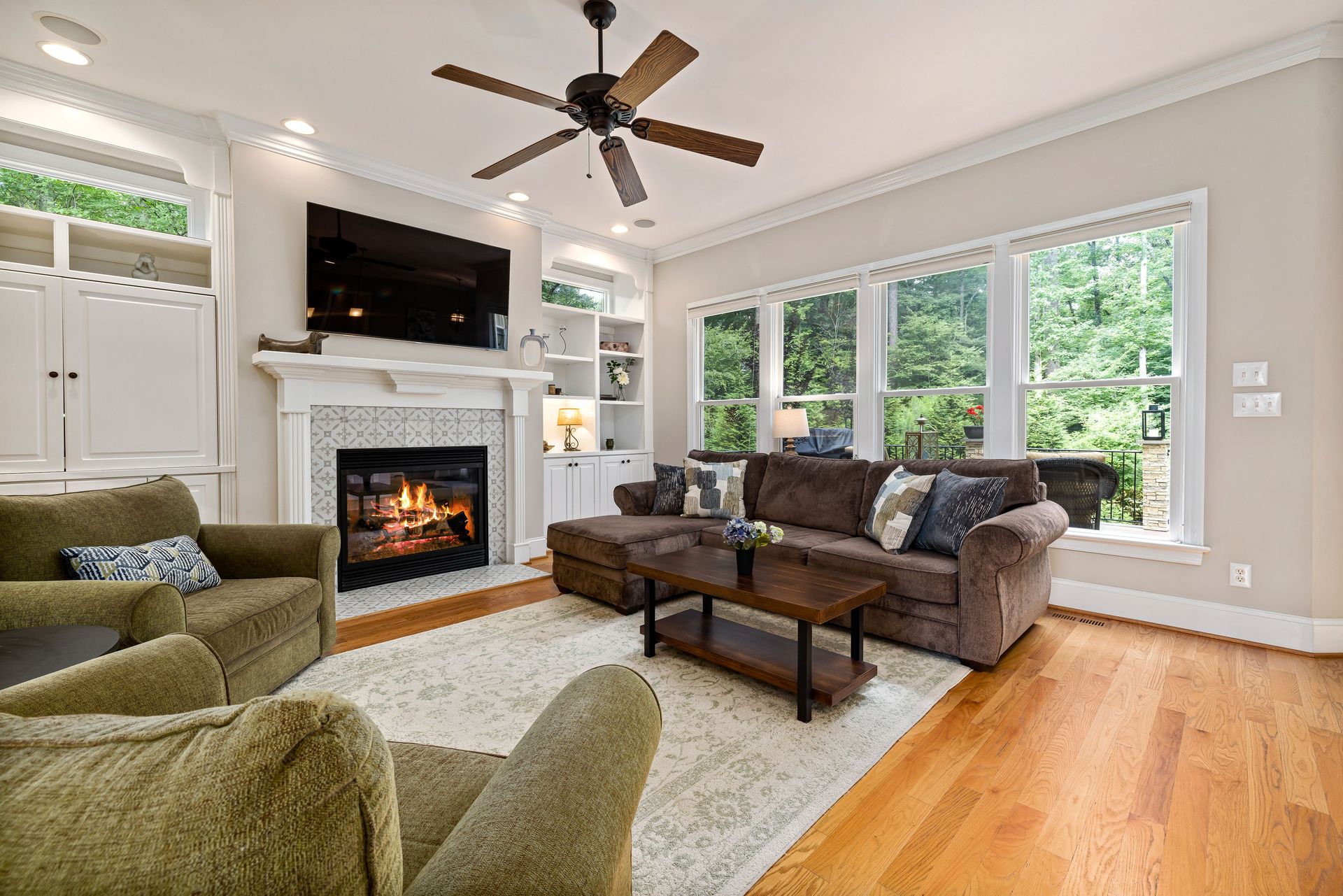 A well-designed living room featuring a fireplace, comfortable seating, and ample natural light.